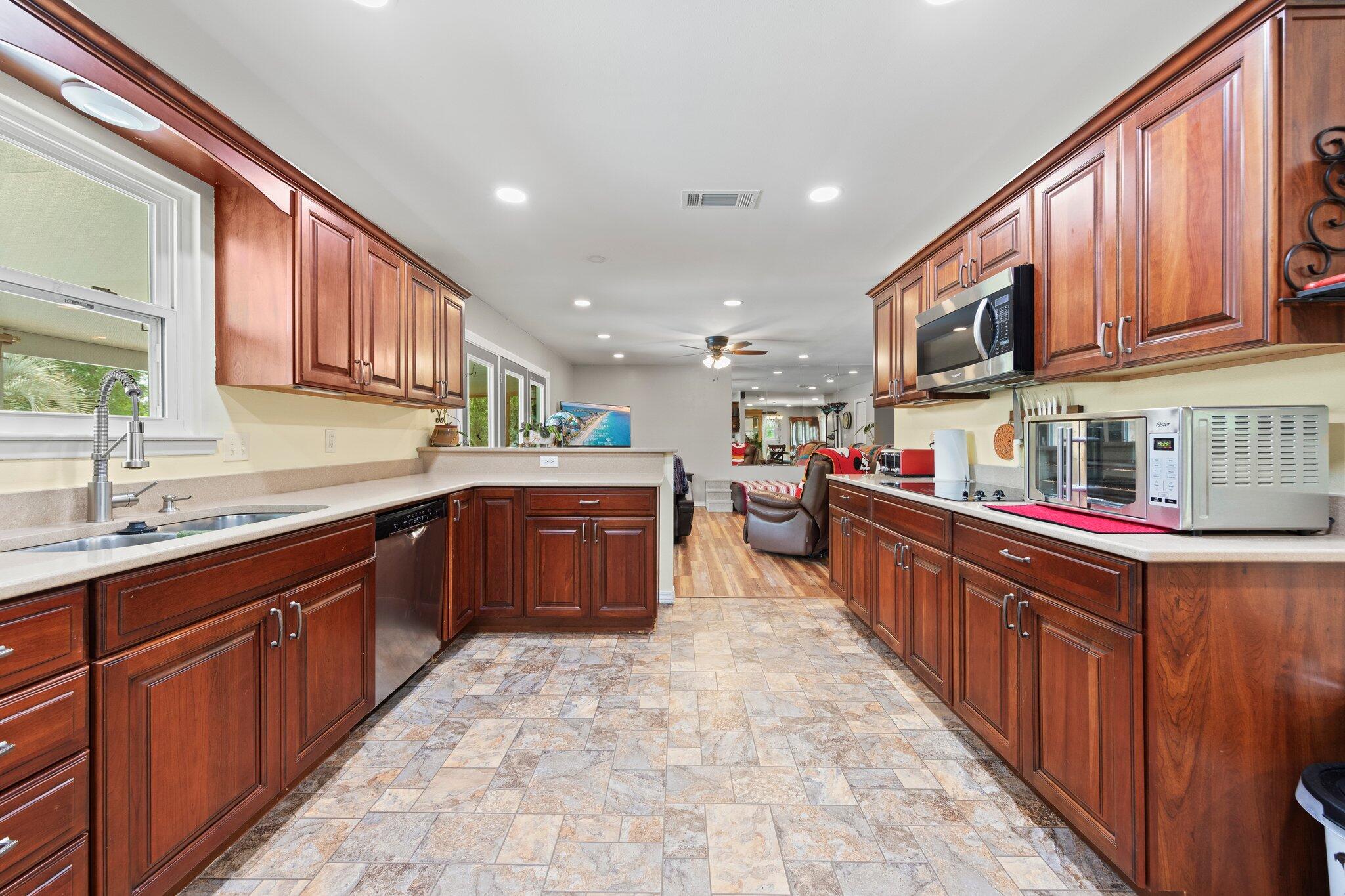 1120 Tallokas Road Crestview, FL 32536 - Photo 2 of 55 a kitchen with stainless steel appliances granite countertop wooden cabinets a sink and dishwasher a oven with wooden cabinets