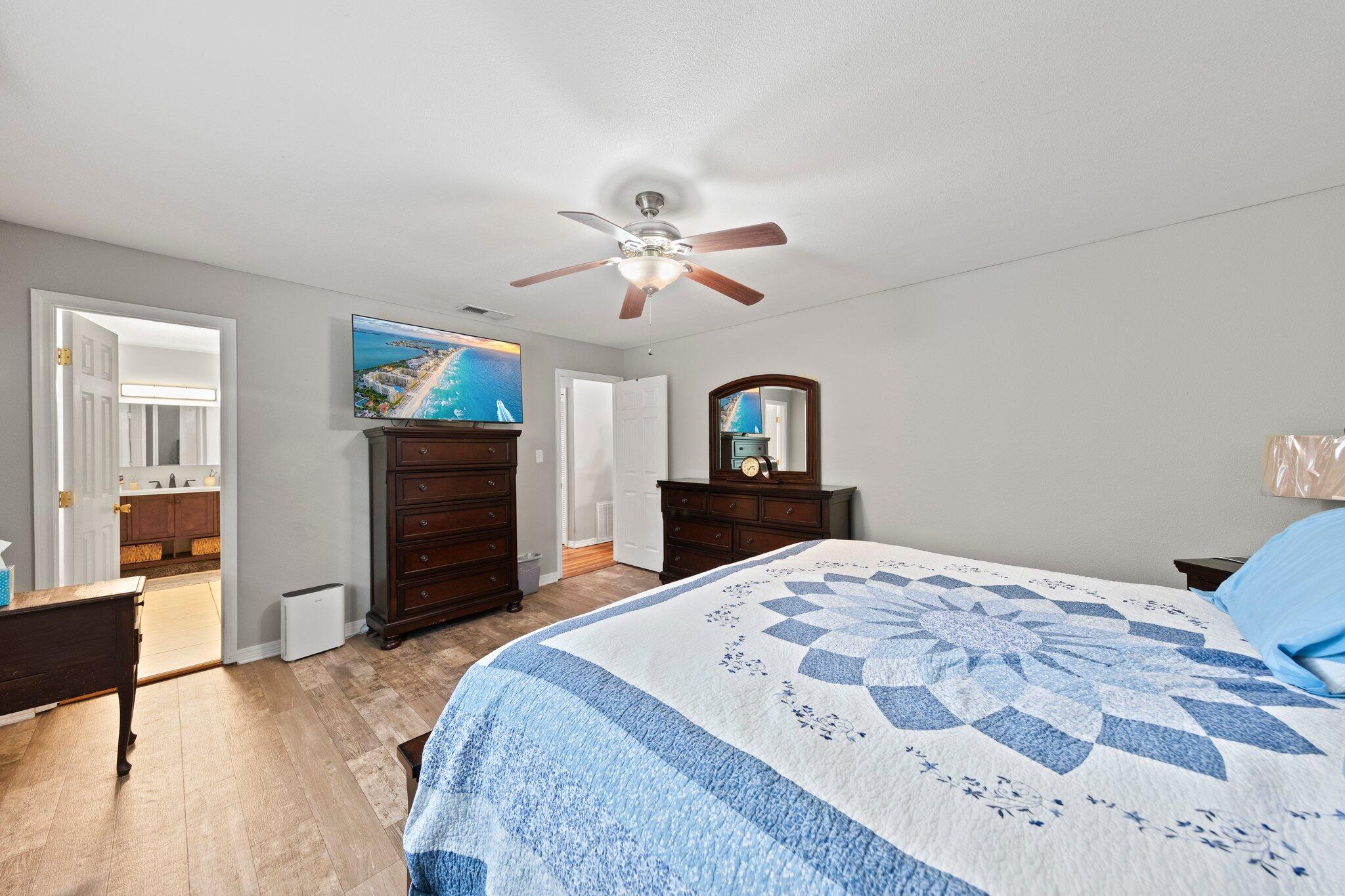 1120 Tallokas Road Crestview, FL 32536 - Photo 22 of 55 a bedroom with a large bed and a chandelier