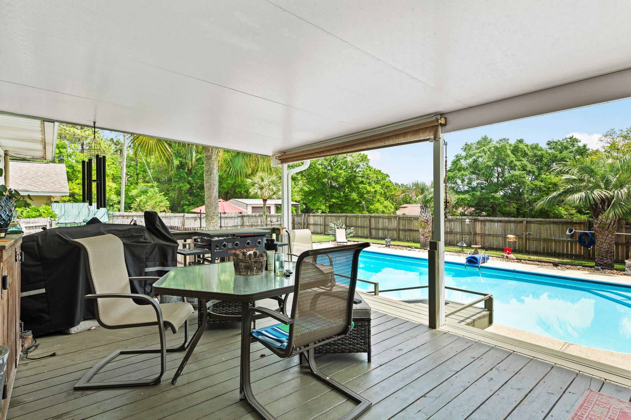 1120 Tallokas Road Crestview, FL 32536 - Photo 27 of 55 a view of a patio with chairs and table potted plants with wooden floor