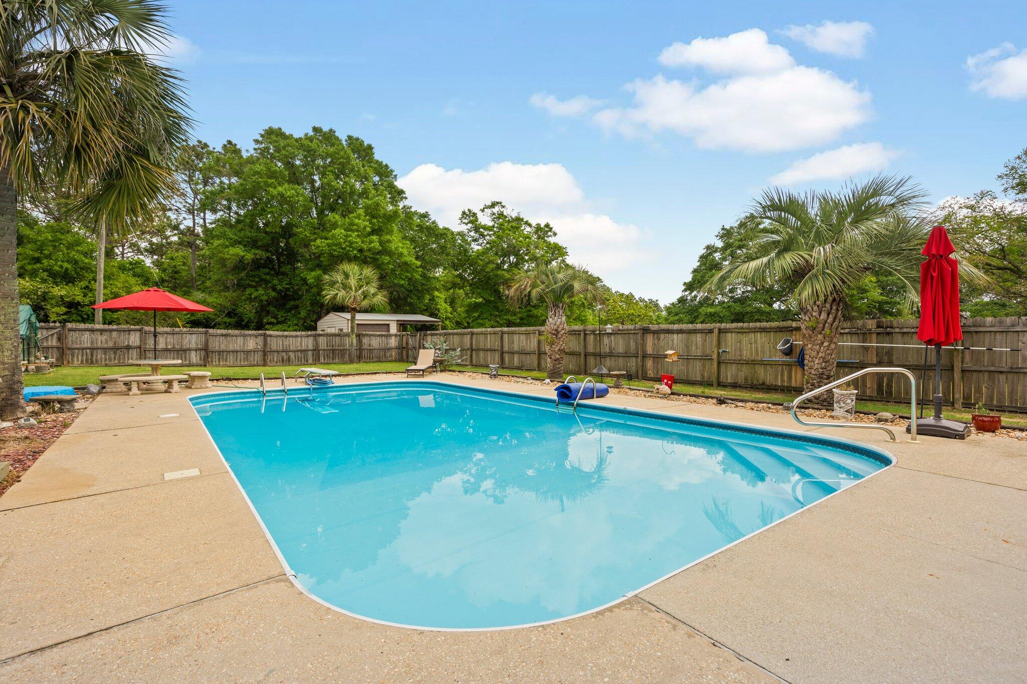 1120 Tallokas Road Crestview, FL 32536 - Photo 35 of 55 a view of a swimming pool with a lounge chair