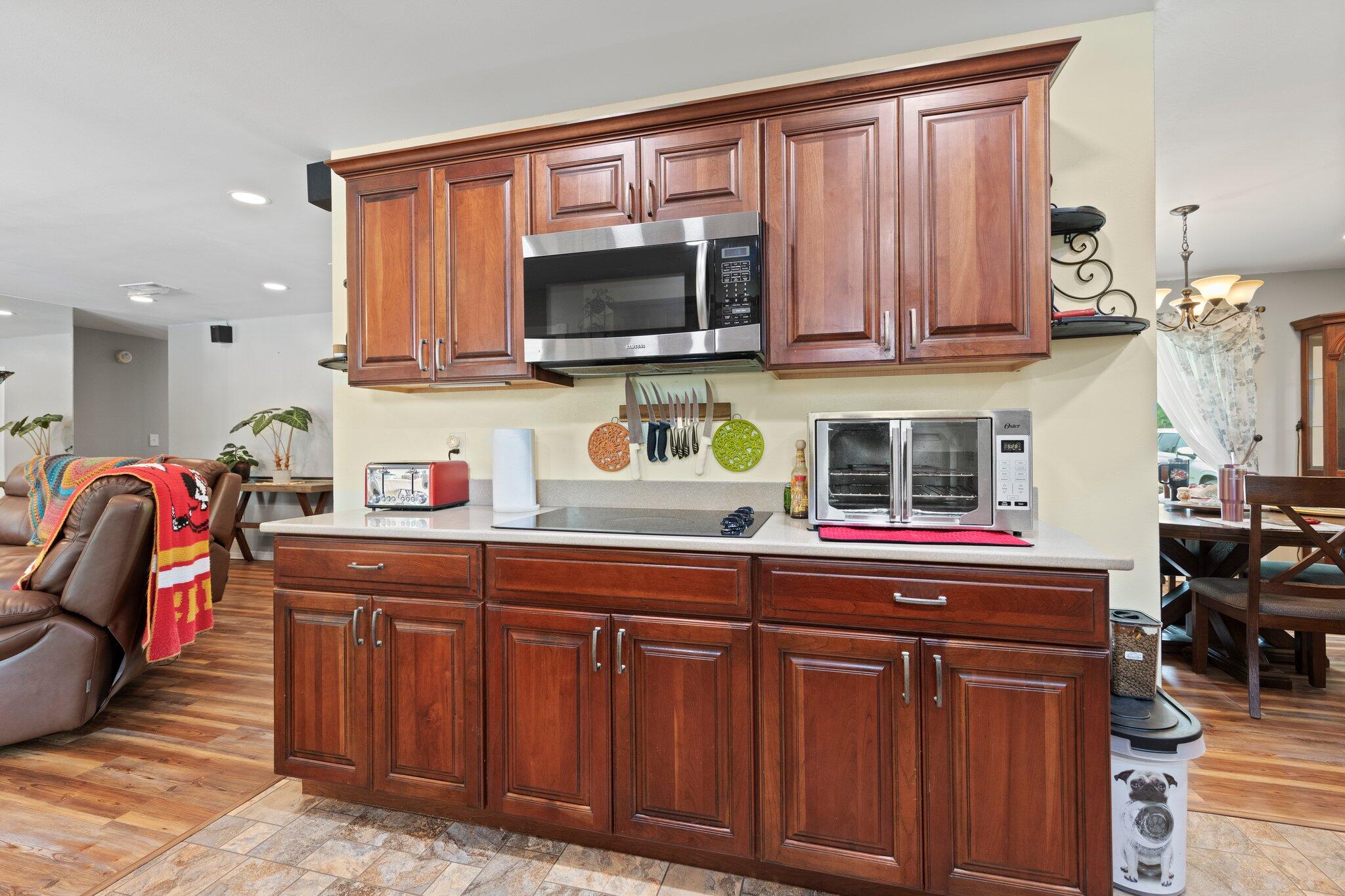 1120 Tallokas Road Crestview, FL 32536 - Photo 5 of 55 a kitchen with stainless steel appliances granite countertop a sink dishwasher stove and microwave with wooden cabinets
