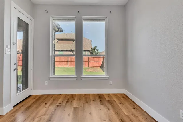 a large white kitchen with kitchen island a sink wooden floor and a living room