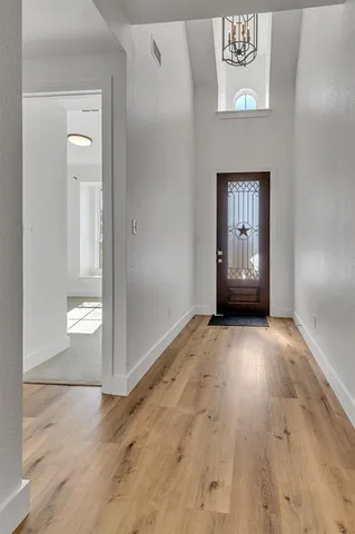 an empty room with wooden floor and door