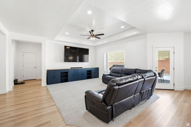 5963 Flattop Drive St. George, UT 84790 - Photo 8 of 45 Spacious living area featuring a tray ceiling with recessed lighting and ceiling fan, wood-finish flooring, and a large built-in media console with storage