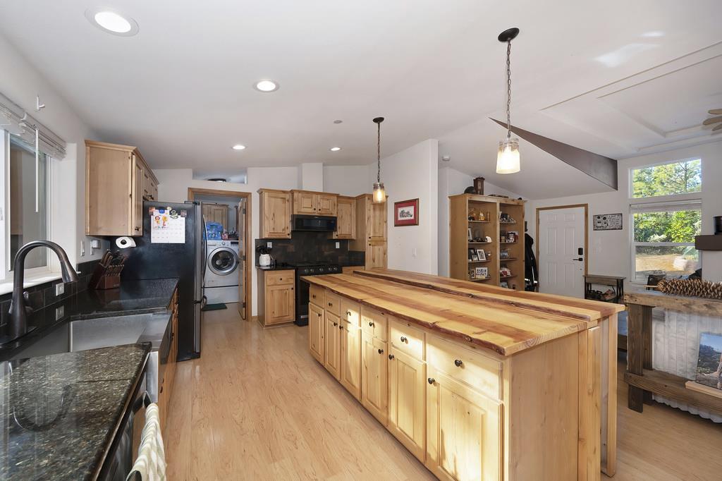 5060 Chestnut Court Georgetown, CA 95634 - Photo 26 of 65 a large kitchen with stainless steel appliances kitchen island granite countertop a sink and a refrigerator