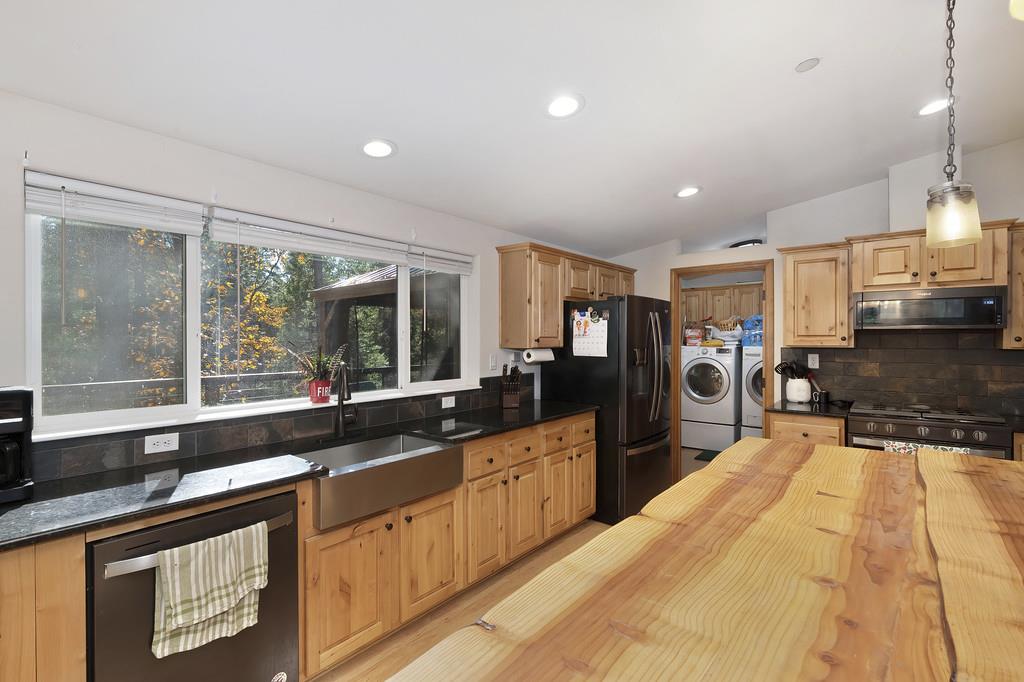 5060 Chestnut Court Georgetown, CA 95634 - Photo 27 of 65 kitchen with butcher block counters, tasteful backsplash, washer and clothes dryer, stainless steel appliances, and extractor fan