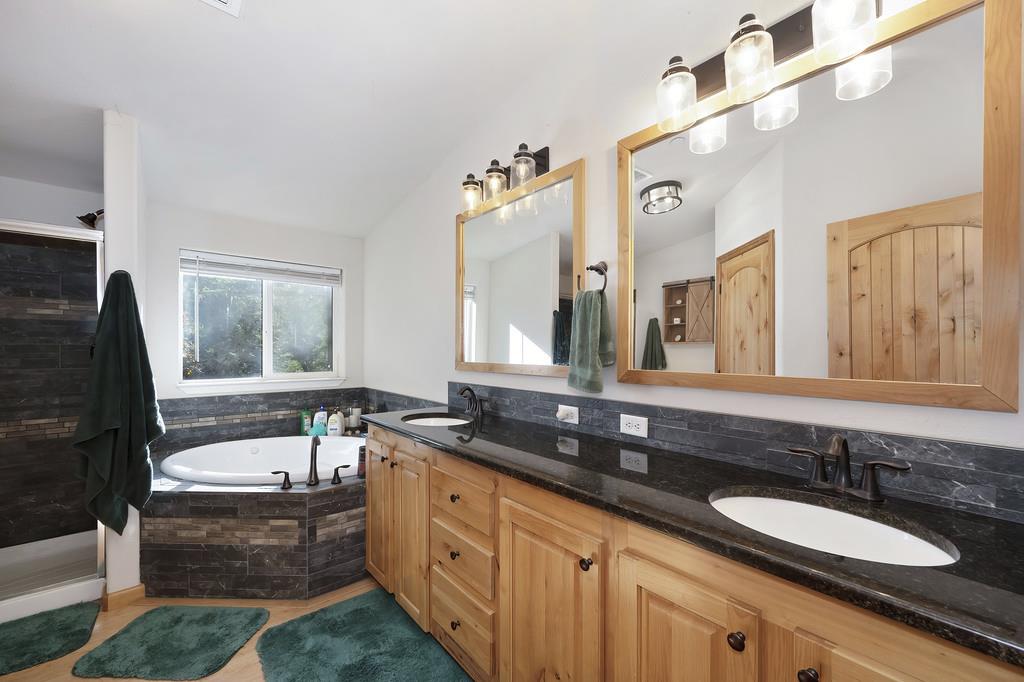 5060 Chestnut Court Georgetown, CA 95634 - Photo 46 of 65 a bathroom with a granite countertop sink and a bathtub