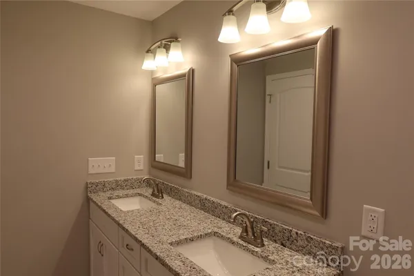 a bathroom with a granite countertop sink and a mirror