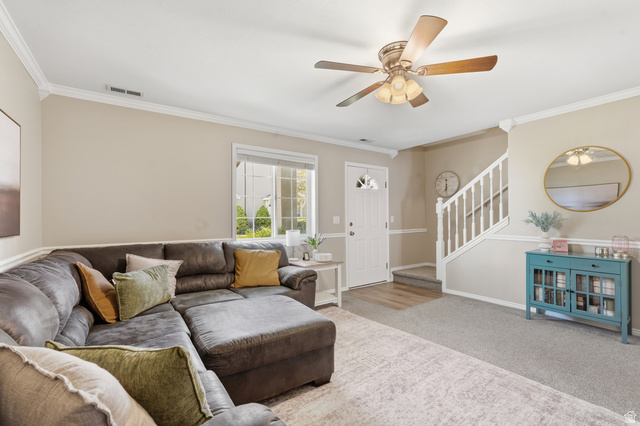 99 Penhurst Place Logan, UT 84341 - Photo 7 of 34 Living area featuring neutral wall tones, crown molding, a ceiling fan, and a front entry door with decorative glass
