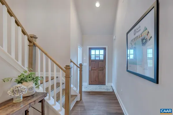 a view of front door with wooden floor and stairs