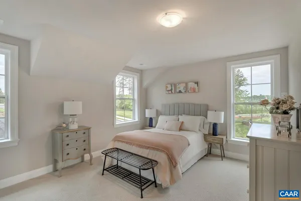a bedroom with a bed a table and chair with window