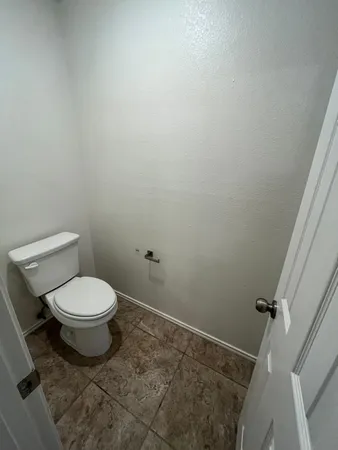 a bathroom with a toilet and a rug