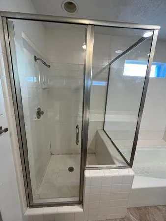 a bathroom with a glass shower door and a mirror