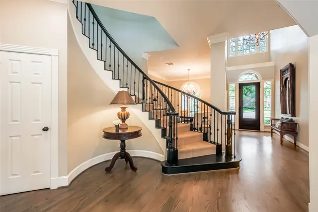 a view of staircase with wooden floor and a chandelier