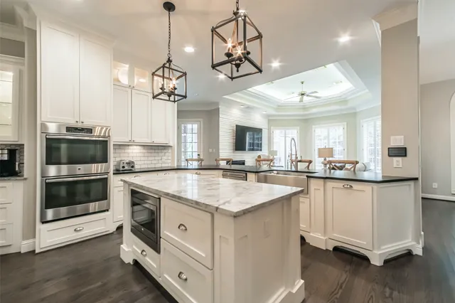 a kitchen with stainless steel appliances granite countertop a sink a stove and a wooden floors