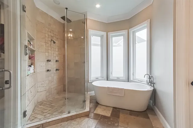 a bathroom with a tub shower and windows