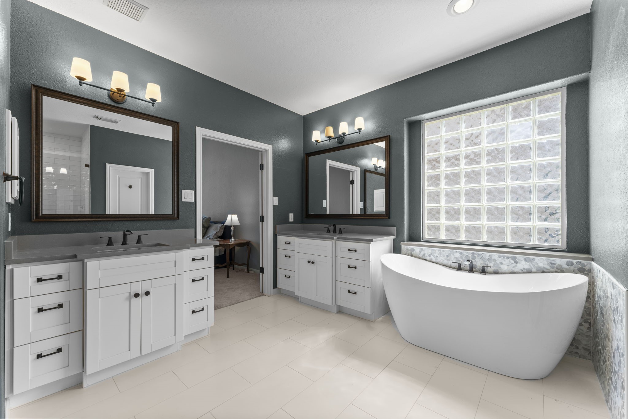 19218 Country Village Drive Spring, TX 77388 - Photo 18 of 30 a spacious bathroom with a double vanity sink a large mirror and a bathtub