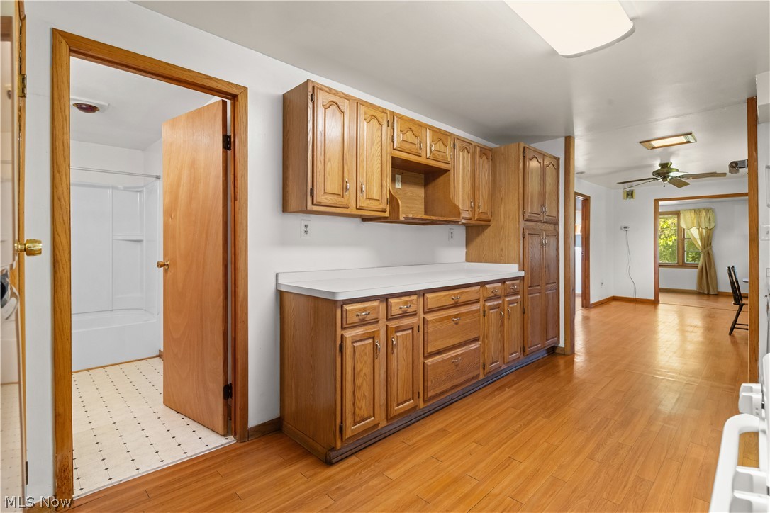409 Edith Avenue Akron, OH 44312 - Photo 13 of 45 Kitchen area featuring wood-finish flooring, ample wood cabinetry, and white countertops