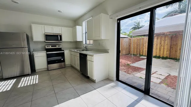 a kitchen with stainless steel appliances granite countertop a refrigerator a stove a sink and a granite counter tops
