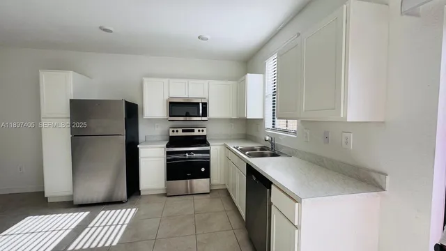 a kitchen with a sink a stove and refrigerator