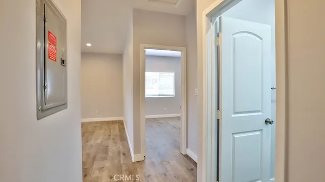 a view of an empty room with wooden floor fireplace and a window