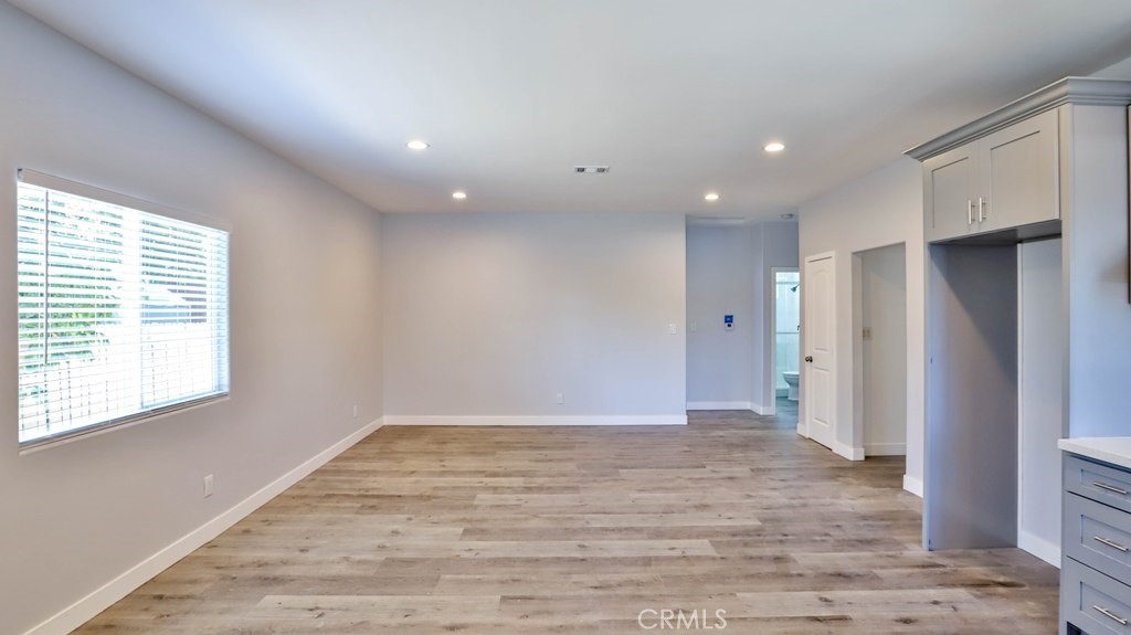 1246 South Baker Street Santa Ana, CA 92707 - Photo 6 of 19 a view of an empty room with wooden floor and a window