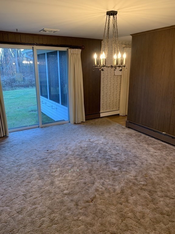144 Harvard Road Stow, MA 01775 - Photo 12 of 40 a view of empty room with chandelier fan and kitchen view