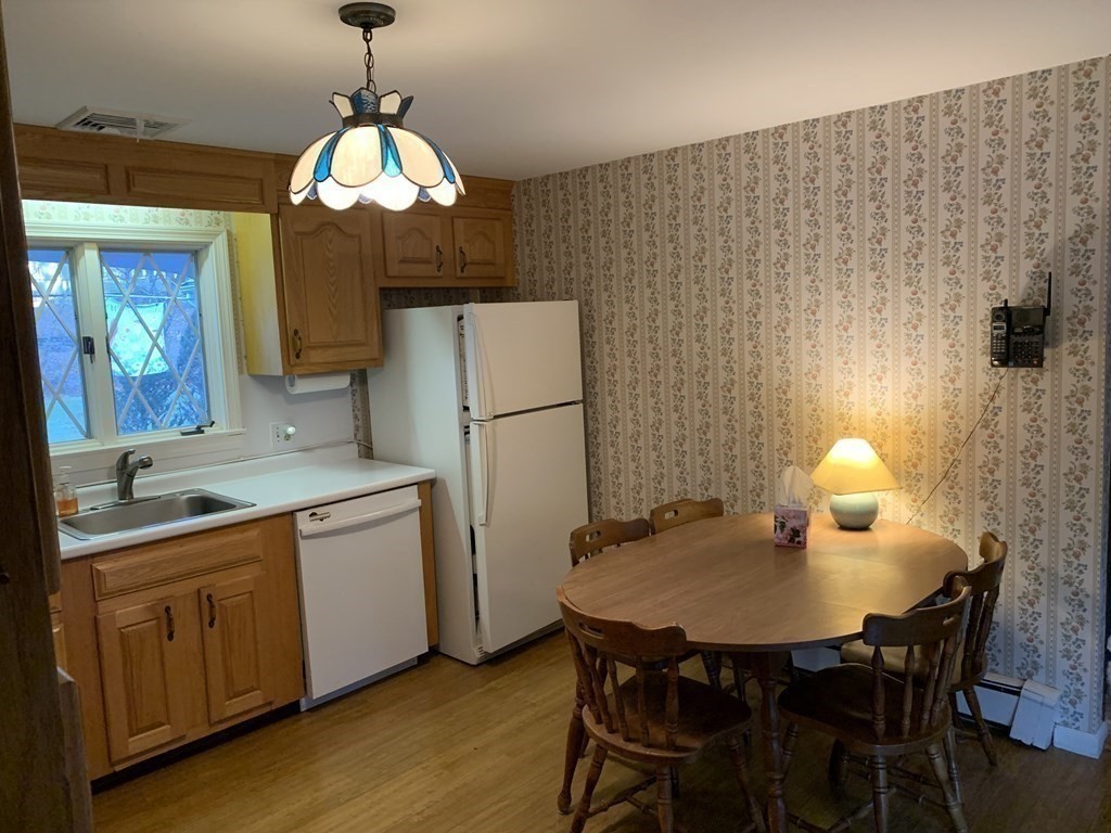 144 Harvard Road Stow, MA 01775 - Photo 6 of 40 a kitchen with stainless steel appliances kitchen island granite countertop a table chairs and a refrigerator