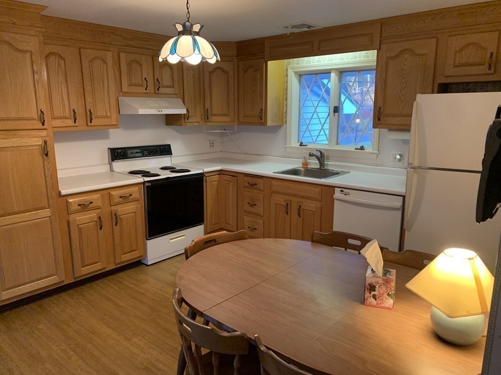 144 Harvard Road Stow, MA 01775 - Photo 7 of 40 a kitchen with stainless steel appliances granite countertop a refrigerator a sink dishwasher a dining table and chairs with wooden floor