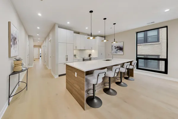 a kitchen with kitchen island a wooden floor and white cabinets