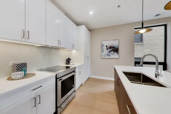 a large kitchen with kitchen island a large island a sink a stove and wooden floor