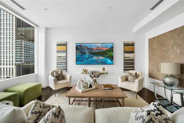 a living room with furniture a flat screen tv and a large window