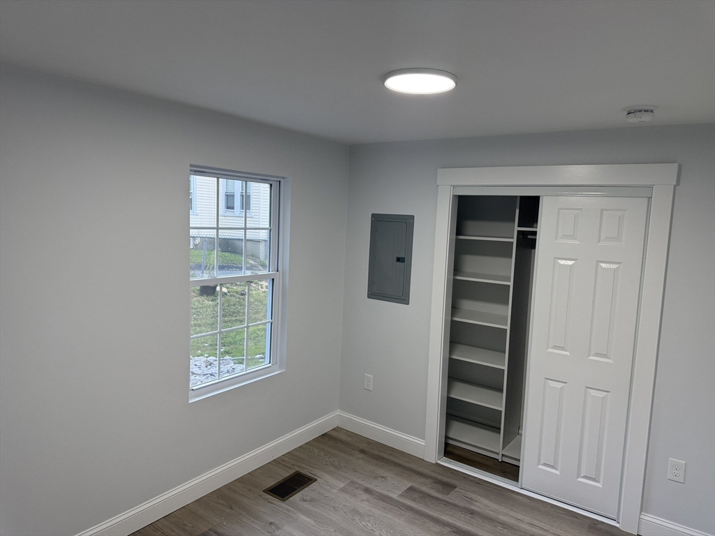 27 Leicester Street, Unit 1 Oxford, MA 01537 - Photo 16 of 26 an empty room with wooden floor closet and windows