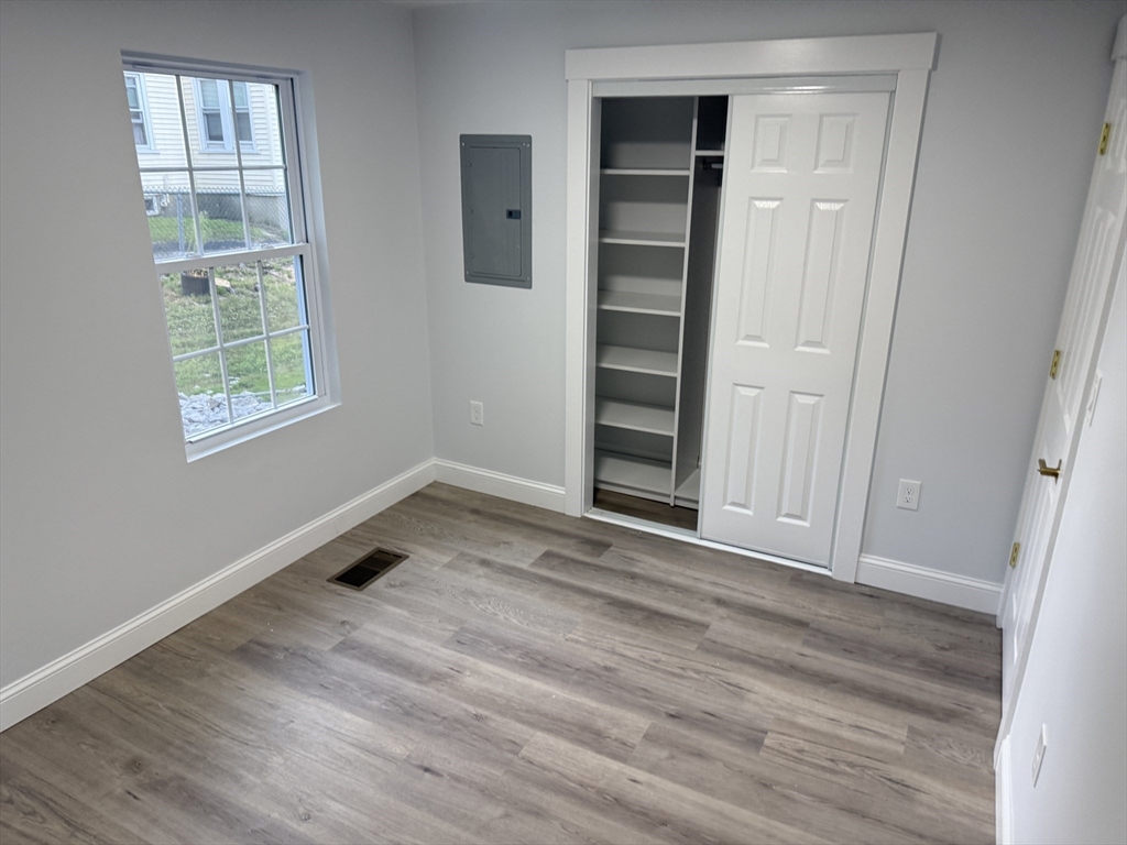 27 Leicester Street, Unit 1 Oxford, MA 01537 - Photo 17 of 26 an empty room with wooden floor closet and windows