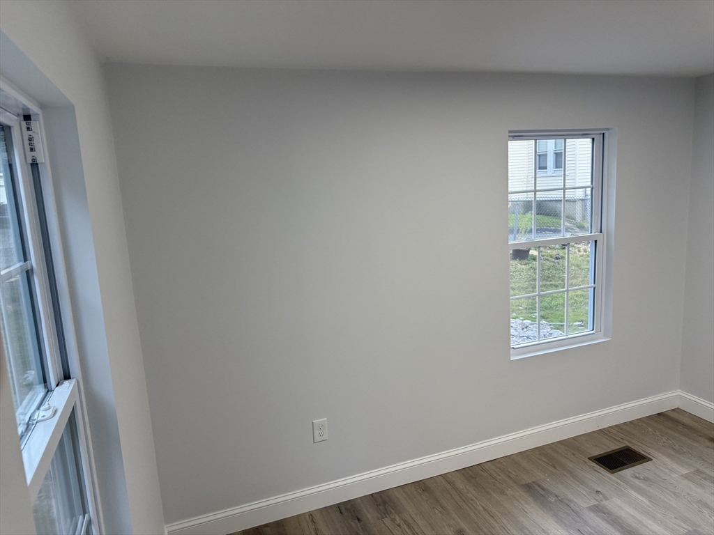 27 Leicester Street, Unit 1 Oxford, MA 01537 - Photo 18 of 26 a view of an empty room with wooden floor and a window