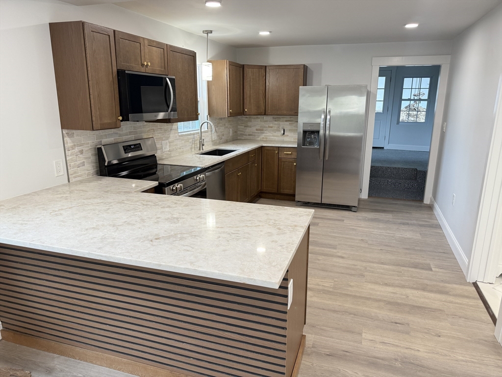 27 Leicester Street, Unit 1 Oxford, MA 01537 - Photo 3 of 26 a kitchen with stainless steel appliances wooden cabinets a refrigerator and a stove