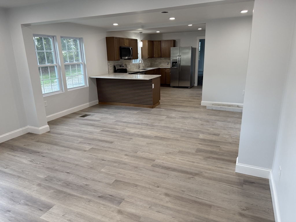 27 Leicester Street, Unit 1 Oxford, MA 01537 - Photo 6 of 26 a view of kitchen with kitchen island stainless steel appliances wooden floor and window