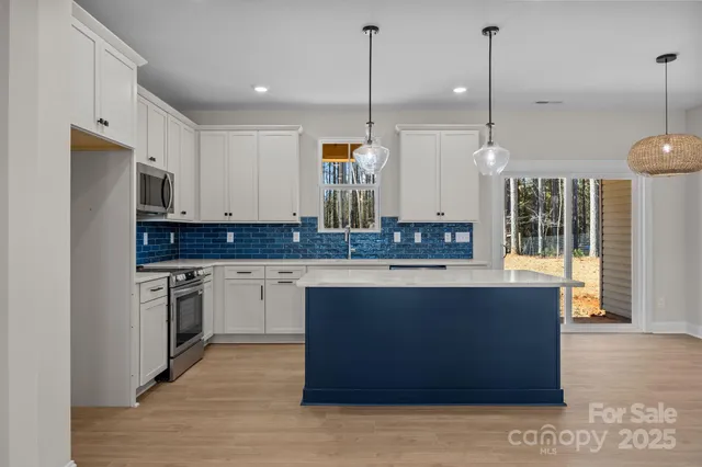 a kitchen with stainless steel appliances granite countertop a stove a sink and a refrigerator