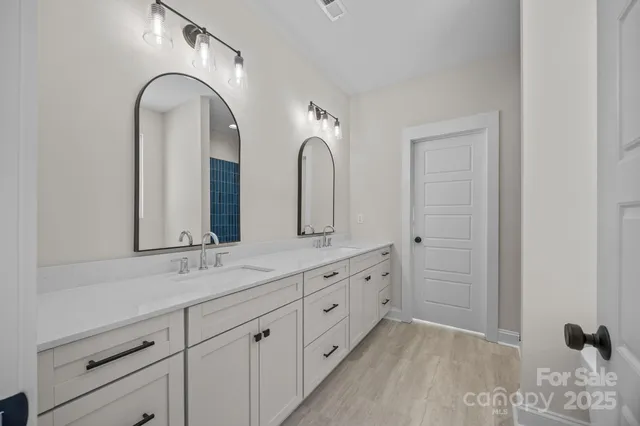 a spacious bathroom with a double vanity sink and mirror