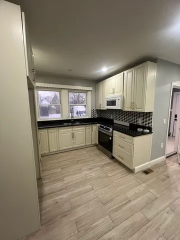 a large kitchen with stainless steel appliances granite countertop a stove and a sink