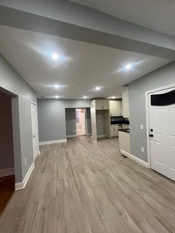 a view of a big room with wooden floor and windows