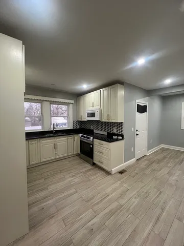 a kitchen with stainless steel appliances kitchen island granite countertop a stove and a refrigerator
