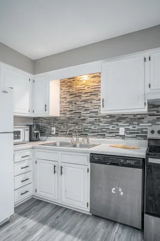 a kitchen with granite countertop white cabinets and a sink