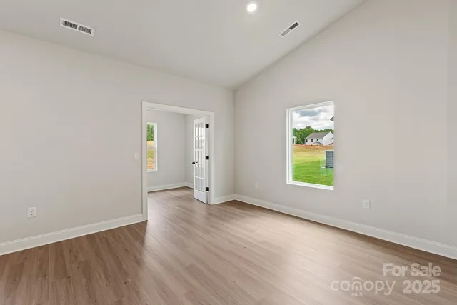 an empty room with a window and wooden floor