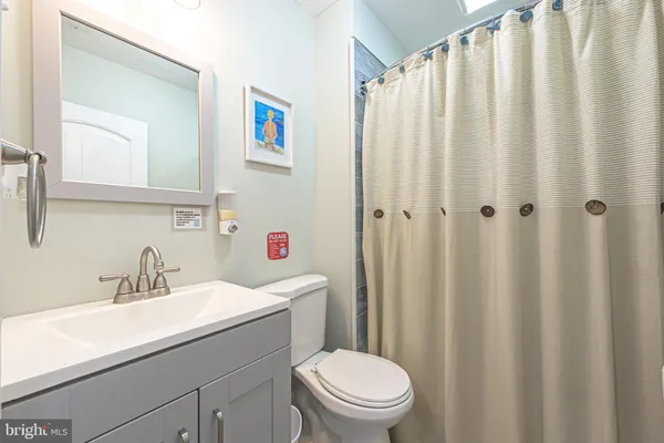 a bathroom with a sink a toilet and shower curtain