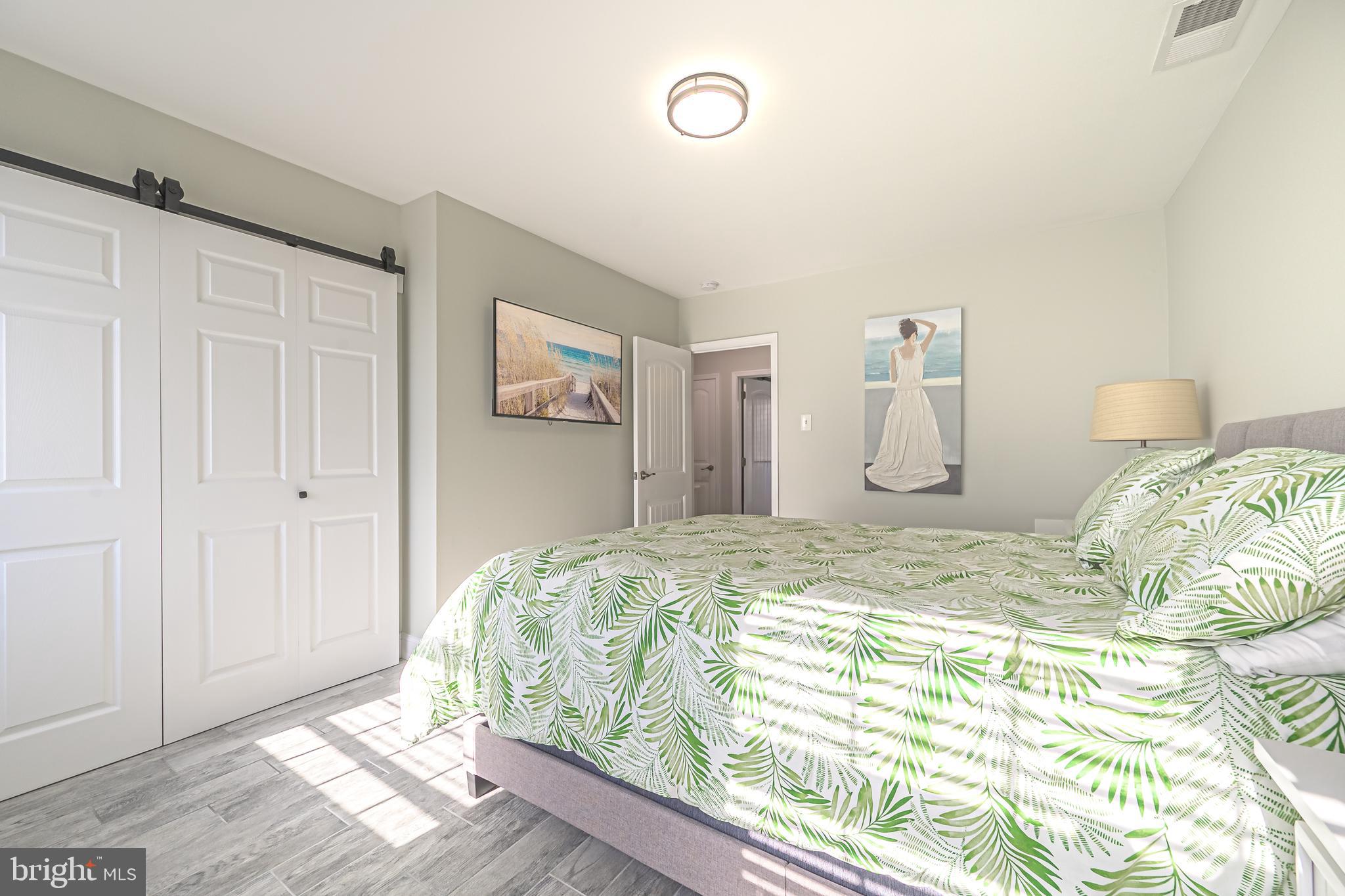 229 10th Street North, Unit 2 Brigantine, NJ 08203 - Photo 14 of 24 a bed sitting in a bedroom next to a cabinet