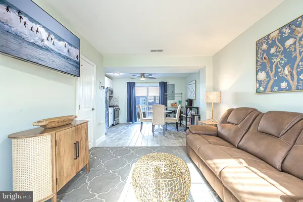 a living room with furniture and a open to kitchen view