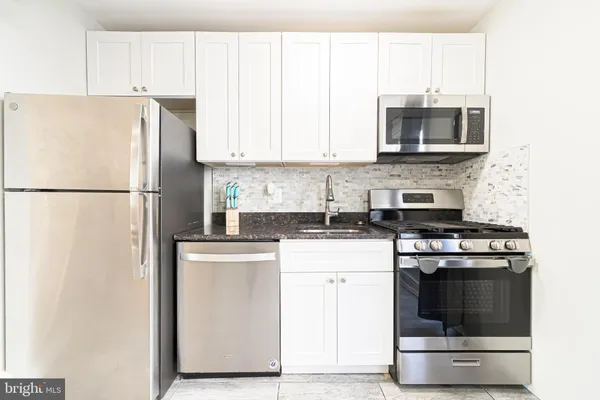 a kitchen with a stove a sink and a refrigerator