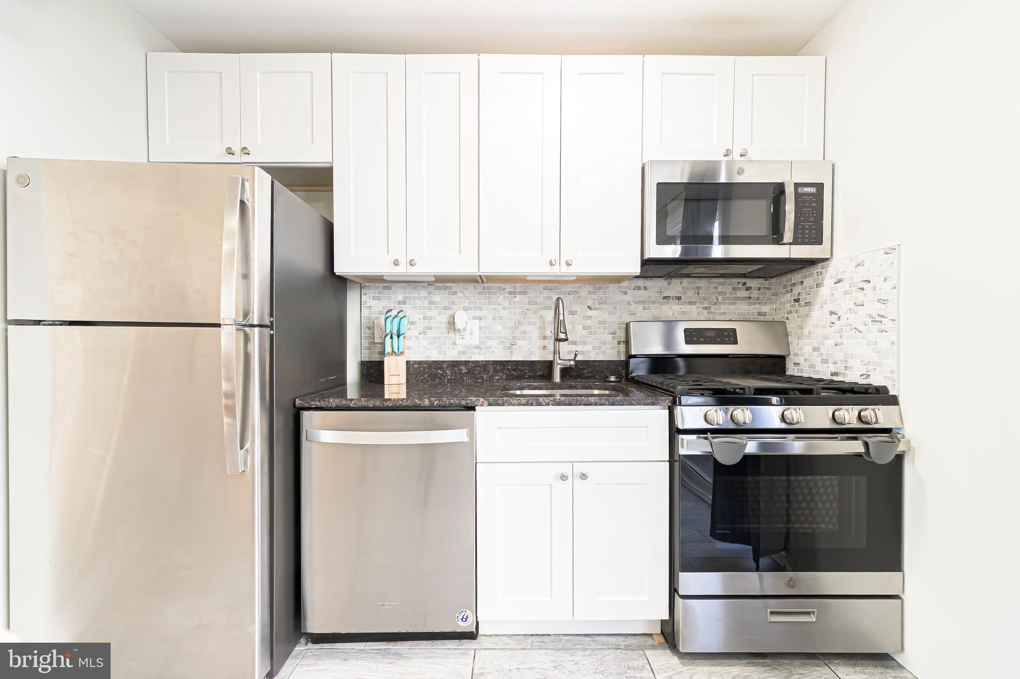 229 10th Street North, Unit 2 Brigantine, NJ 08203 - Photo 6 of 24 a kitchen with a stove a sink and a refrigerator