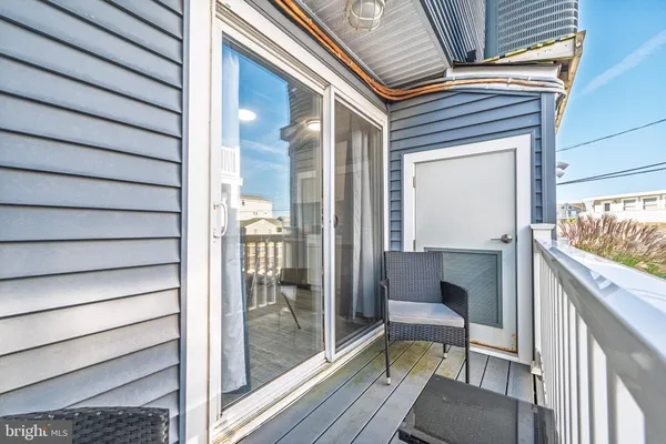 a balcony with view of dining room and wooden floor